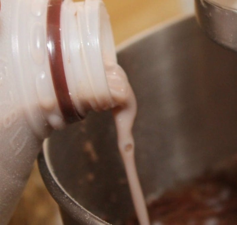 pouring chocolate milk into a bowl