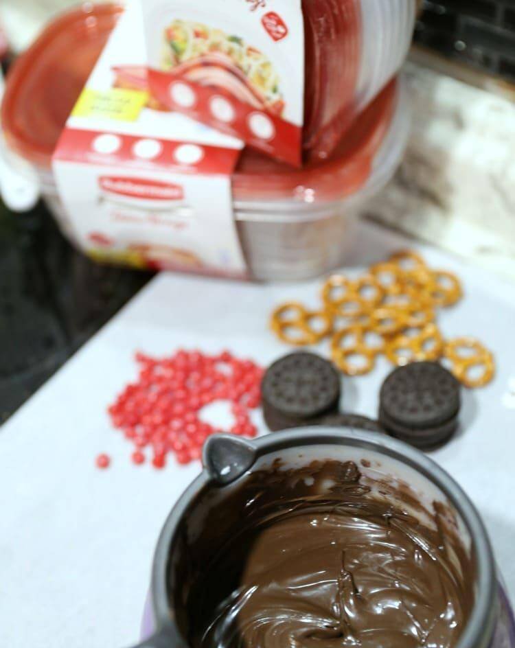 How to Make Reindeer Christmas Cookie Pops 11 oreos, red hots, pretzels and melted chocolate on counter