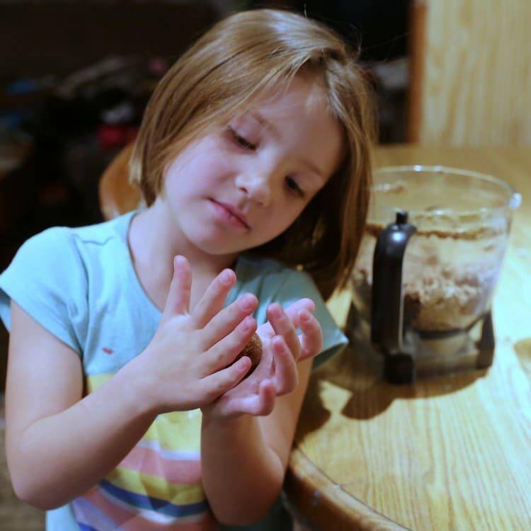 No-Bake Chocolate Peanut Butter Breakfast Balls 13 Jennifer brockmans daughter rolling protein balls with hands