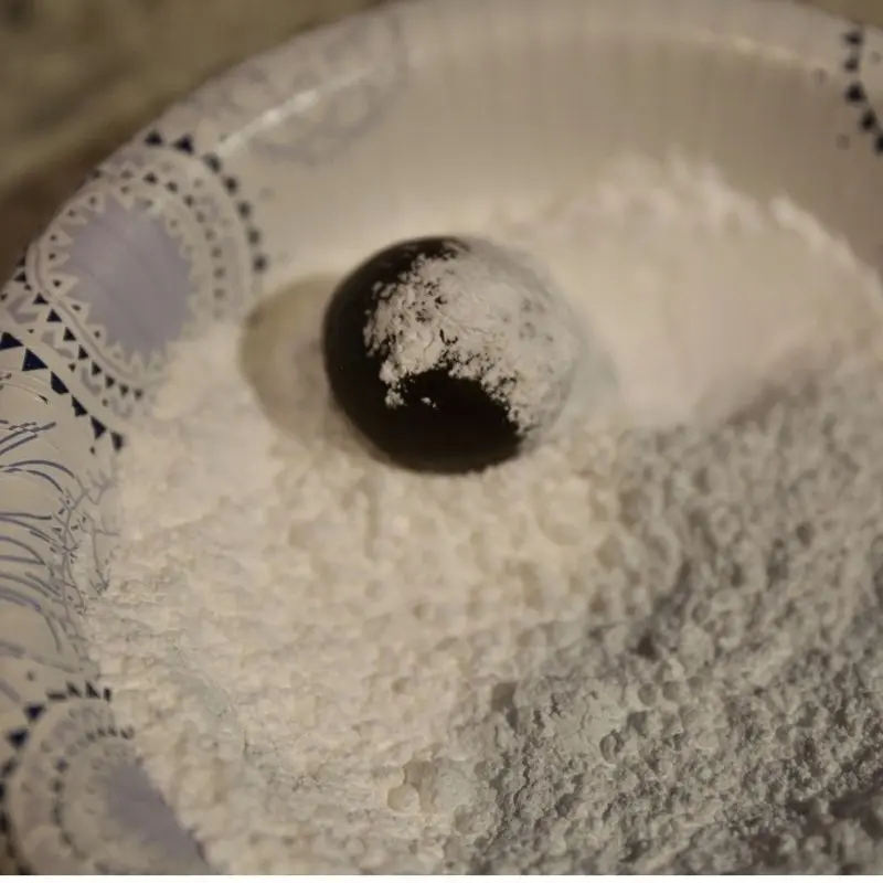 rolling brownie cookie dough in powder sugar | Half Baked Media