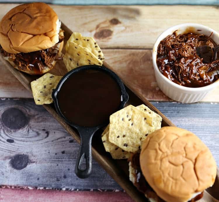 bbq sandwiches on plate with bbq sauce and chips