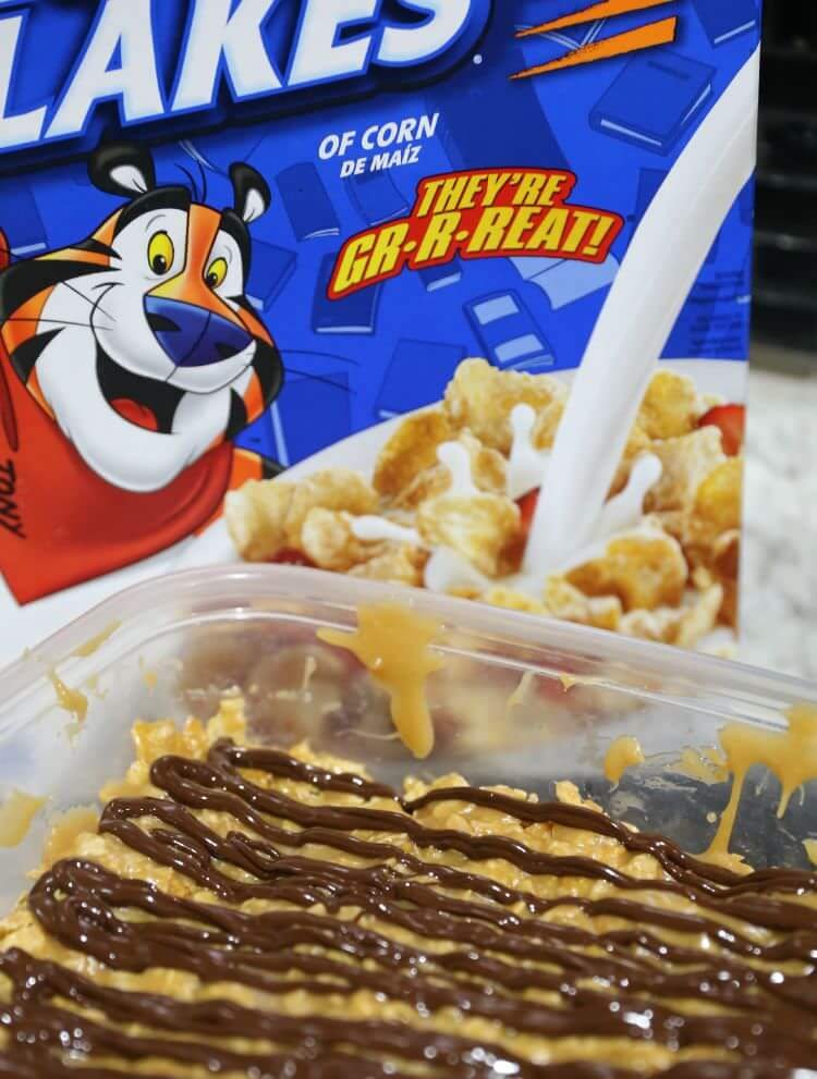 No Bake Peanut Butter Cereal Bars 12 No Bake Peanut Butter Cereal Bars in Tupperware container with frosted flakes cereal box in background