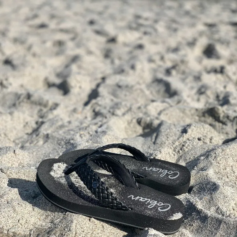 Suns Out, Funds Out: Win a $25 Amazon Gift Card! 11 black flip flops sitting on a sandy beach