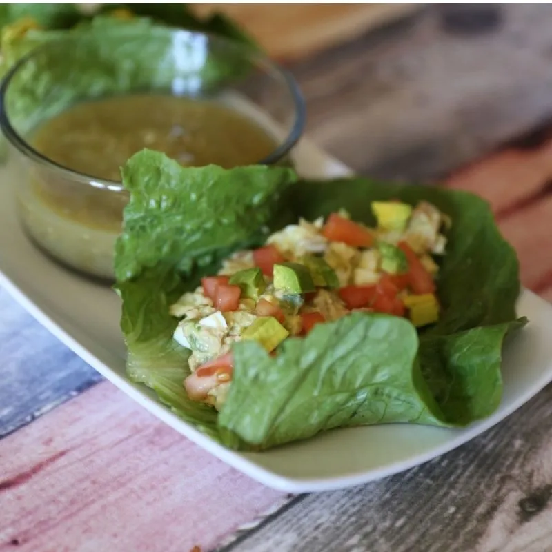 The Ultimate Avocado Tuna Salad Wrap (High-Protein & Low Calorie Lunch) 10 avocado tuna salad on romaine lettuce on white plate next to glass bowl of salsa verde
