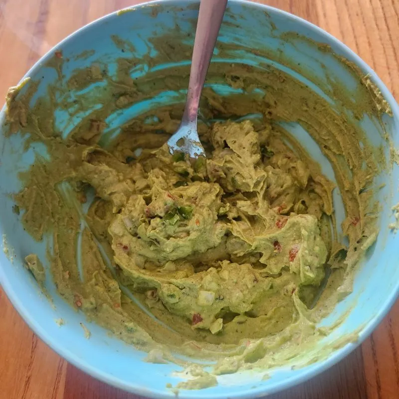 Holy Guacamole Deviled Eggs inside mixed together in a blue bowl