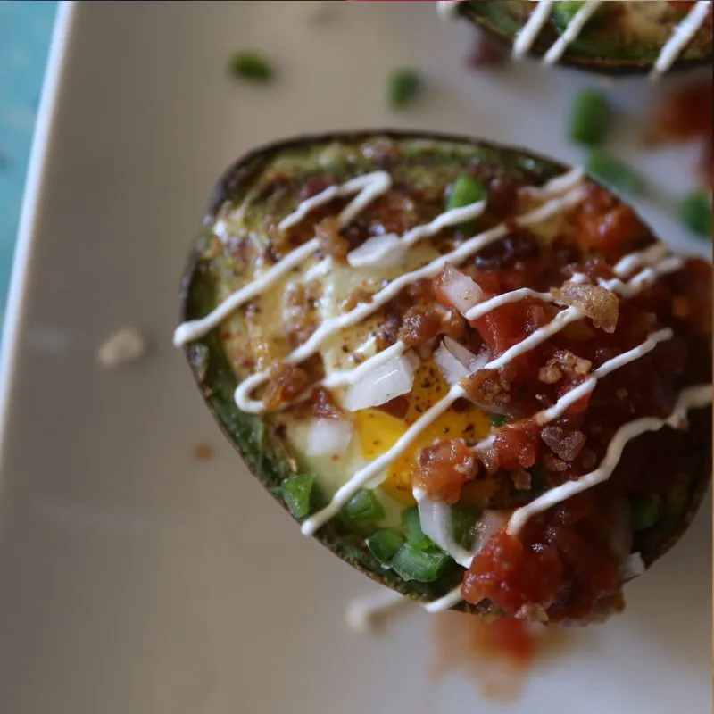 Loaded Southwest Baked Avocado Egg Boats with toppings on white plate