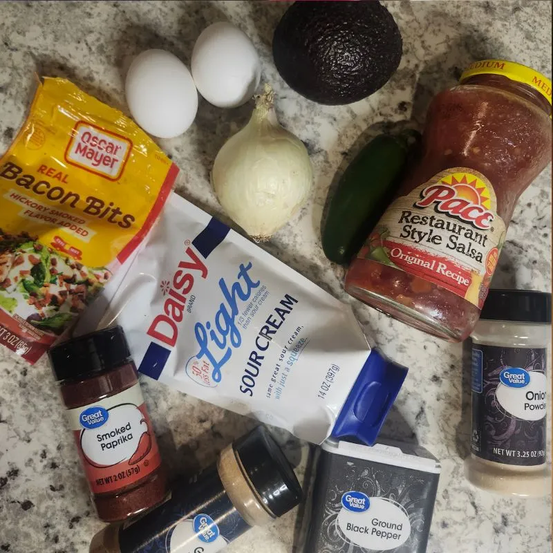 ingredients to make Loaded Southwest Baked Avocado Egg Boats eggs, avocados, bacon bits, salsa, sour cream, seasonings and more. 