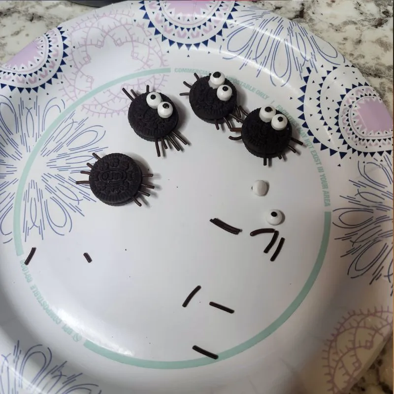 mini Oreos on a paper plate that look like little spiders