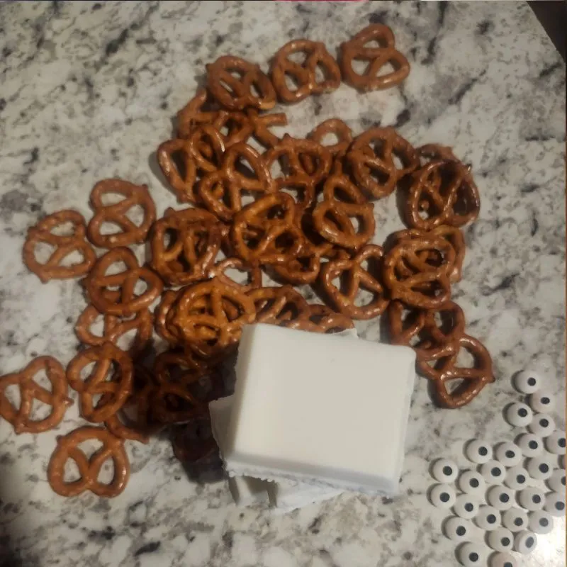 pretzels, almond bark and candy eyes on the counter