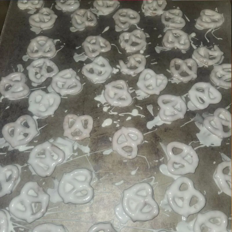 pretzels covered in almond bark laying on cookie sheet covered with partchment paper