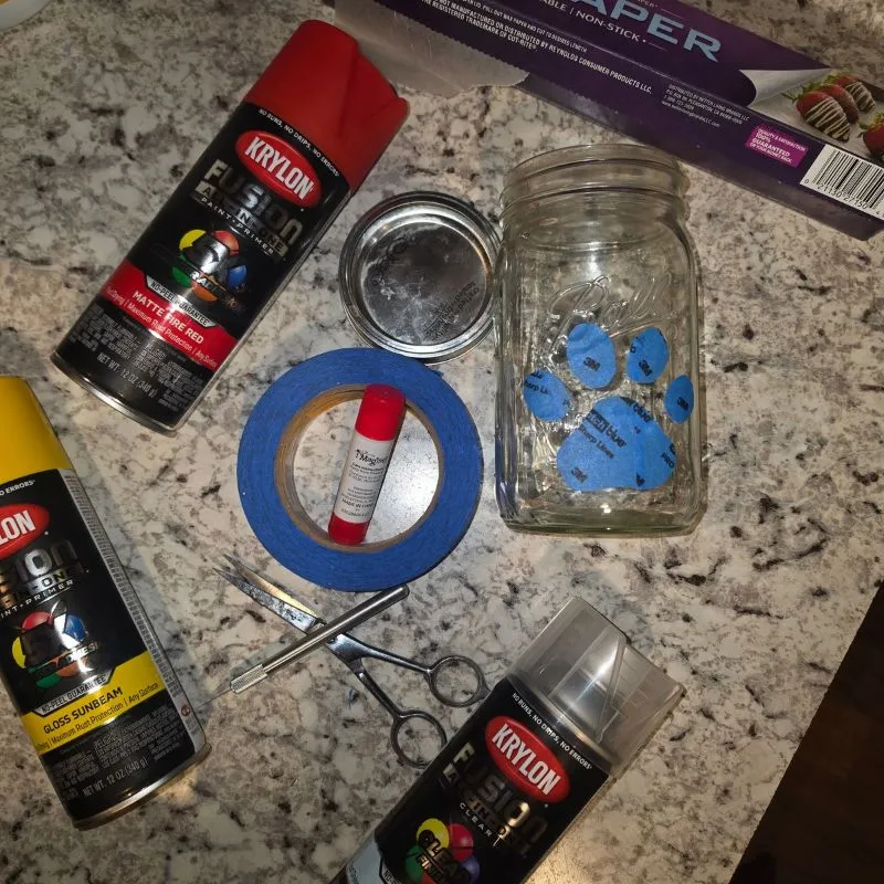 Awesome DIY Dog Treat Jar Using a Mason Jar 11 spray paint, painters tape, mason jar with homemade sticker and other items needed to make homemade diy treat jar