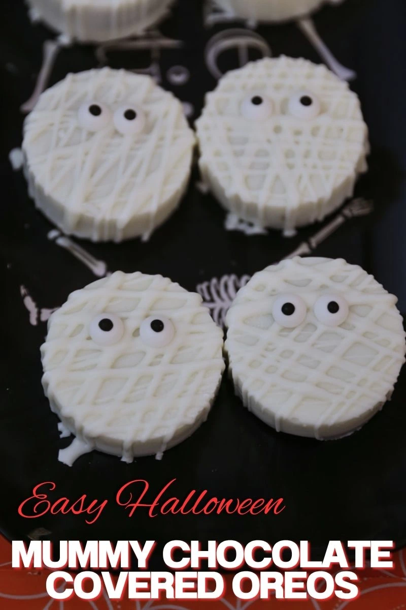 Easy Mummy Oreos (Halloween Chocolate Covered Oreos) lined on a black platter
