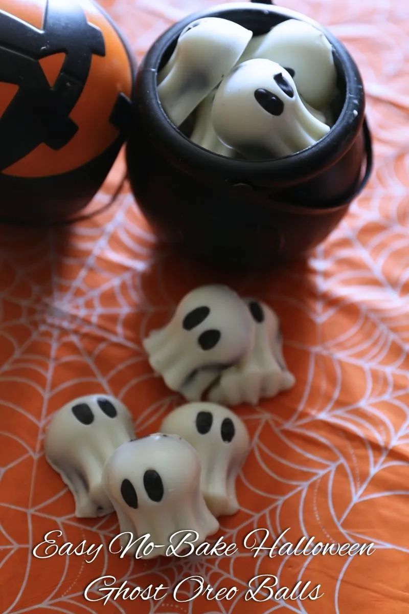 Easy No Bake Halloween Ghost Oreo Balls 7 Easy No Bake Halloween Ghost Oreo Balls laying orange table cloth with spider webs and piled in a Calderon