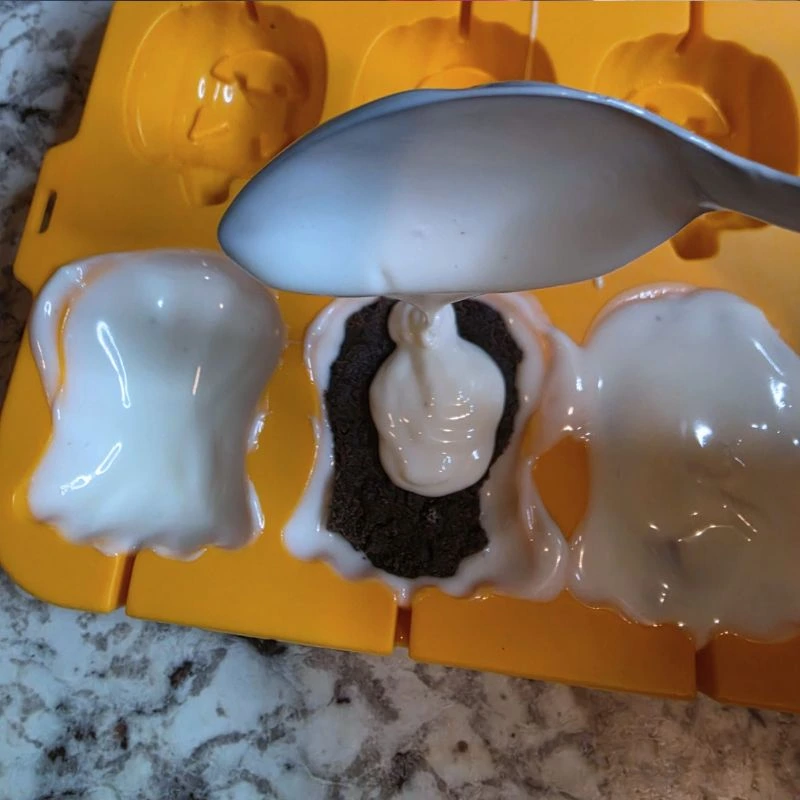 Easy No Bake Halloween Ghost Oreo Balls 12 covered oreo ball in white chocolate in ghost mold.