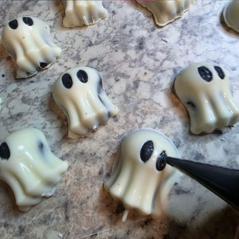 Easy No Bake Halloween Ghost Oreo Balls 15 Piping black candy melts into eyes of